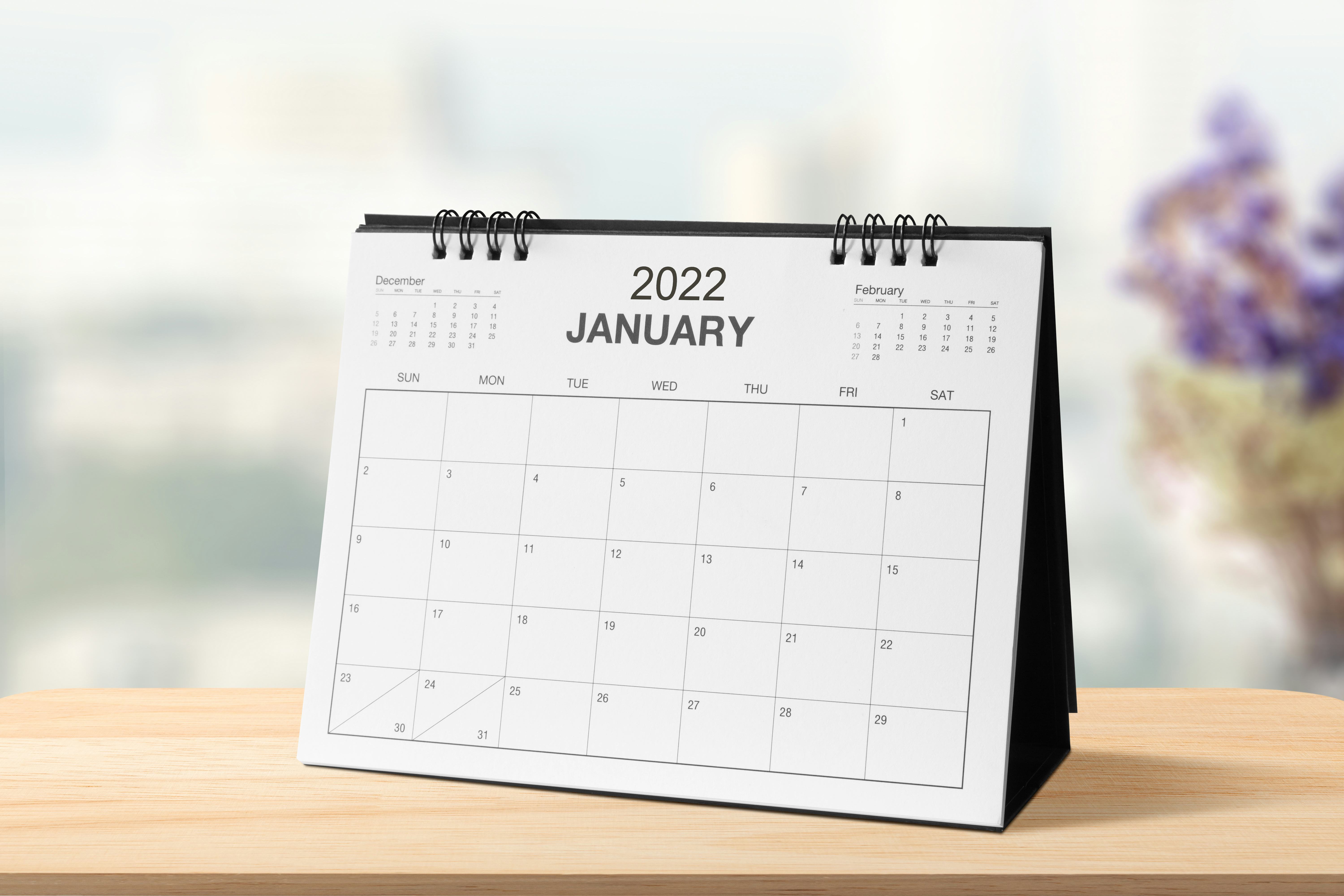 Monthly dest calendar on table in the bright room or modern office  for 2022 year.  side view
