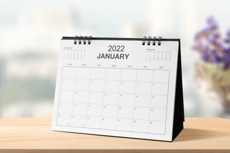 Monthly dest calendar on table in the bright room or modern office for 2022 year. side view