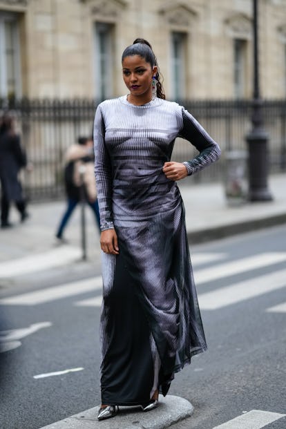 PARIS, FRANCE - JANUARY 26: A guest wears a large silver pearls with blue / green / red stoned penda...