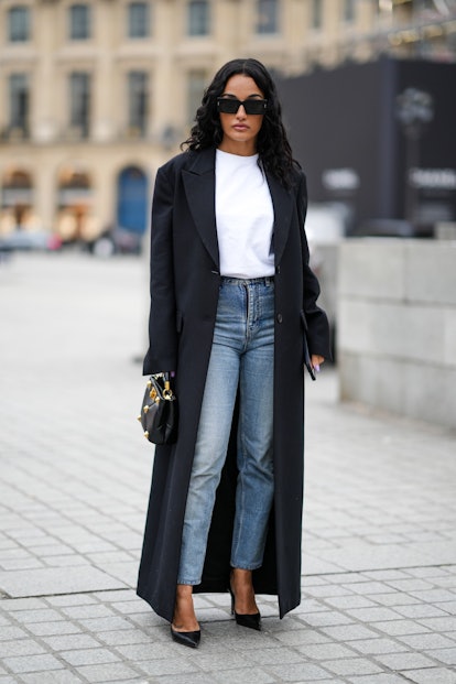 PARIS, FRANCE - JANUARY 26: Amina Muaddi wears black sunglasses, a white t-shirt, a black long coat,...