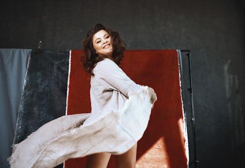 Beautiful woman dancing against the red background