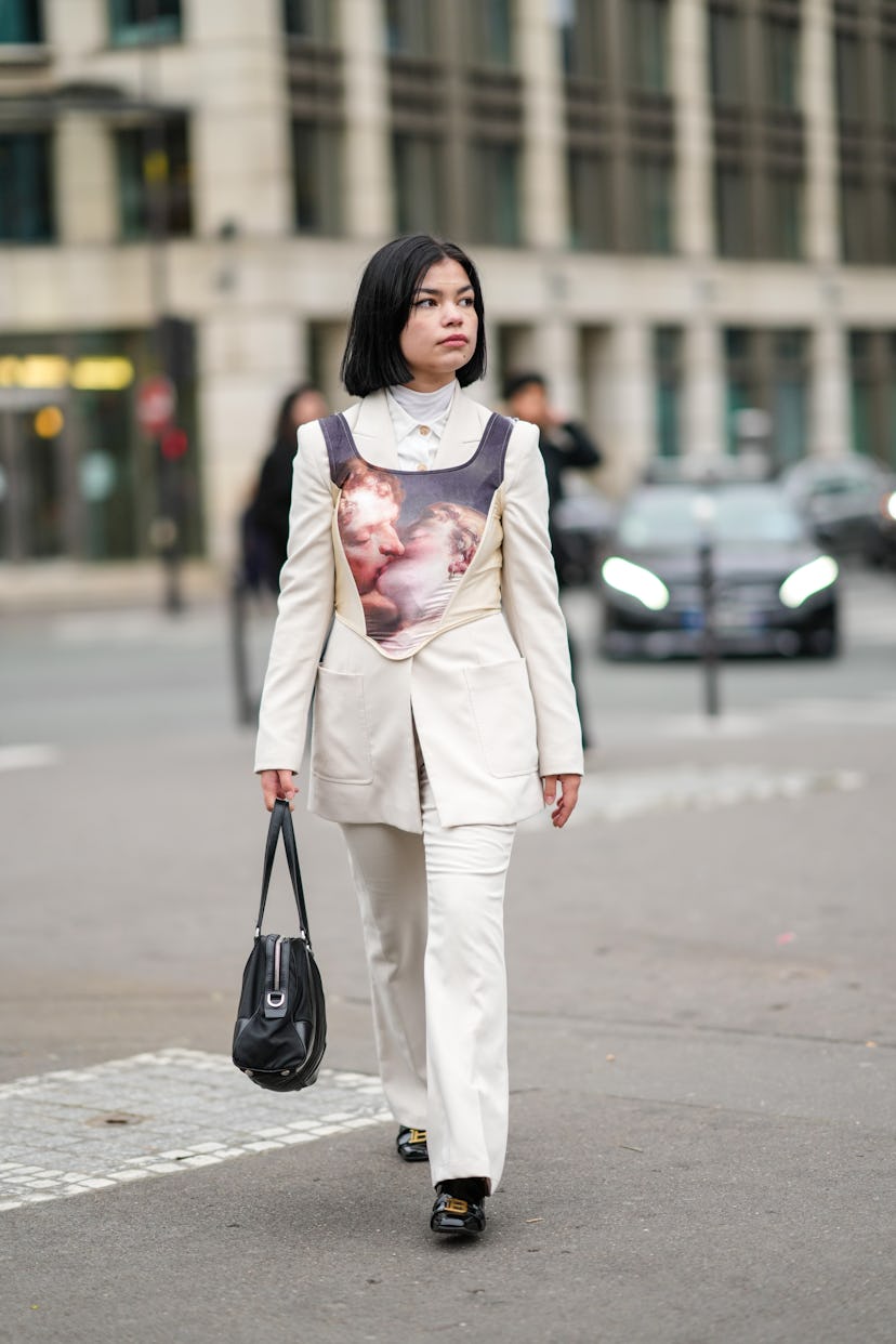 PARIS, FRANCE - JANUARY 27: A guest wears a white turtleneck pullover, a white shirt, a white latte ...