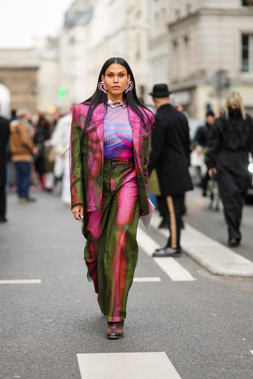 PARIS, FRANCE - JANUARY 26: A guest wears pale purple metallic large pendant earrings, a matching pa...