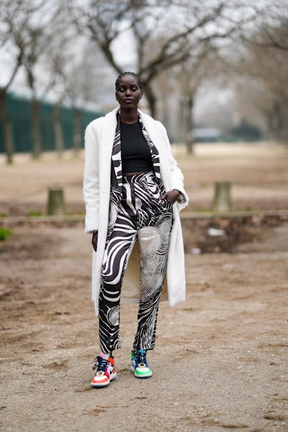 PARIS, FRANCE - JANUARY 25: A model wears earrings, a black ribbed cropped t-shirt, a black and whit...