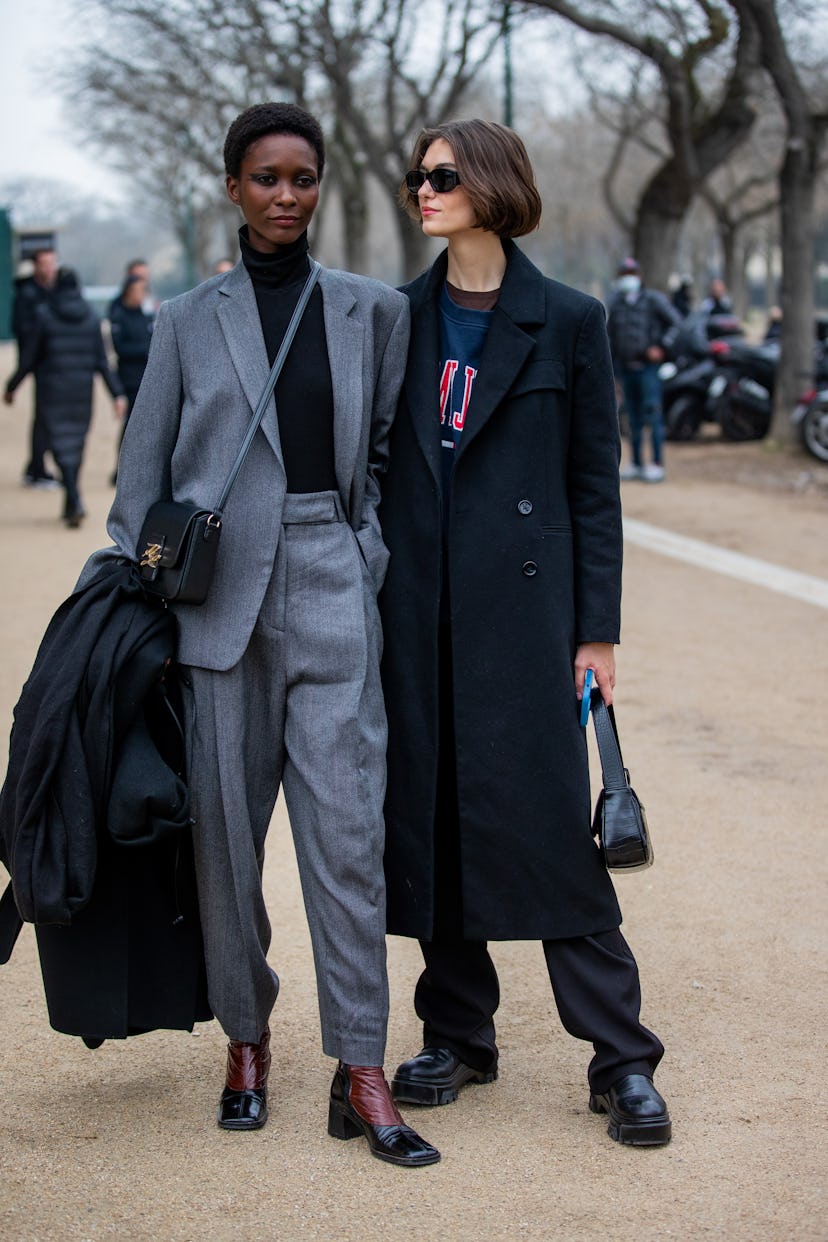 PARIS, FRANCE - JANUARY 25: Models seen wearing grey suit, wool coat outside Chanel during Paris Fas...