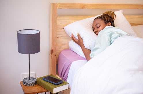 Young african woman sleeping comfortably on bed in morning at home