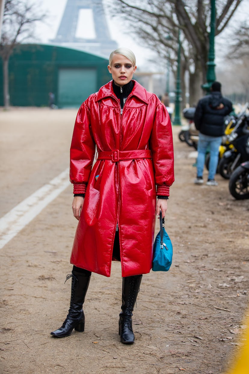 PARIS, FRANCE - JANUARY 25: A model is seen wearing red belted coat, black boots, blue bag outside C...