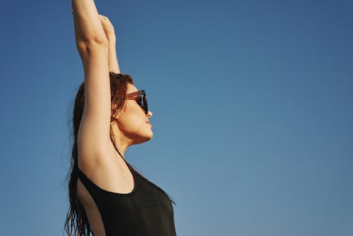 woman enjoying the weather with her arms up in the air