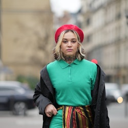 PARIS, FRANCE - JANUARY 27: A guest wears a red wool / felt beret, a purple / yellow / green large n...