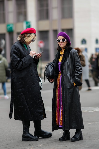 PARIS, FRANCE - JANUARY 27: A guest (L) wears a red wool / felt beret, a purple / yellow / green lar...