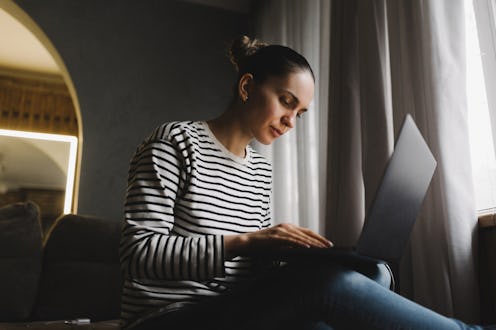 Young woman working from home, freelance in laptop.