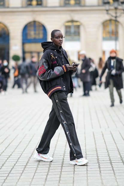 PARIS, FRANCE - JANUARY 26: A model wears a black hoodie sweater, a black felt with black leather sl...