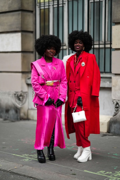 PARIS, FRANCE - JANUARY 26: A guest (L) wears a neon pink silk long dress, a pink velvet blazer jack...