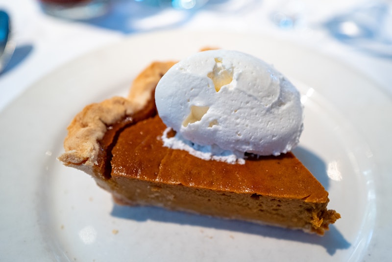 Close-up of slice of pumpkin pie with whipped cream on a white plate, Danville, California, November...
