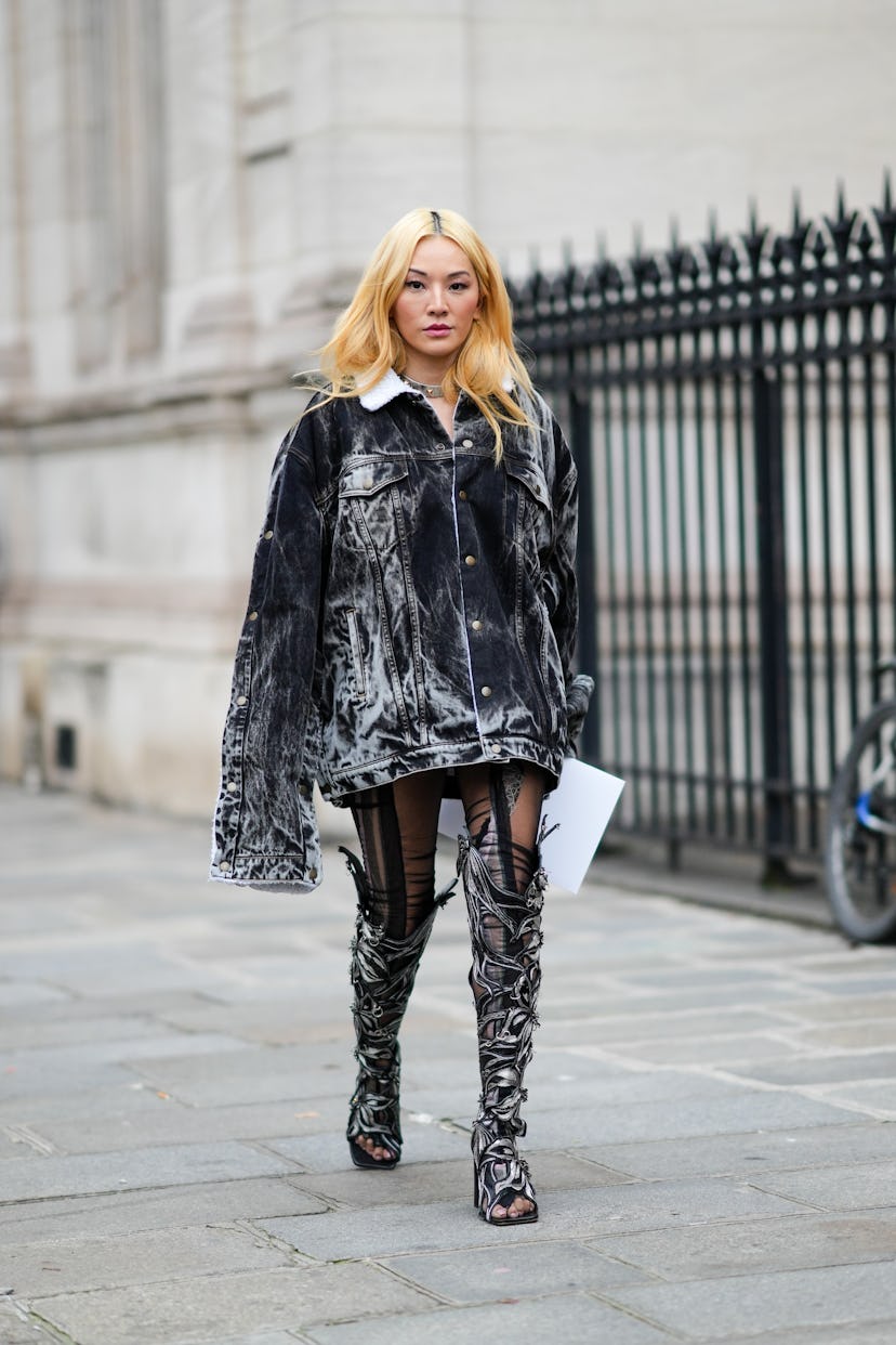 PARIS, FRANCE - JANUARY 26: Tina Leung wears earrings, a silver nailed / studded necklace, a black a...