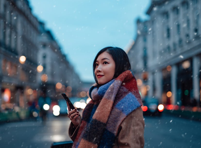 Young woman with scarf and winter coat, thinking about how her lucky zodiac sign will have the best ...