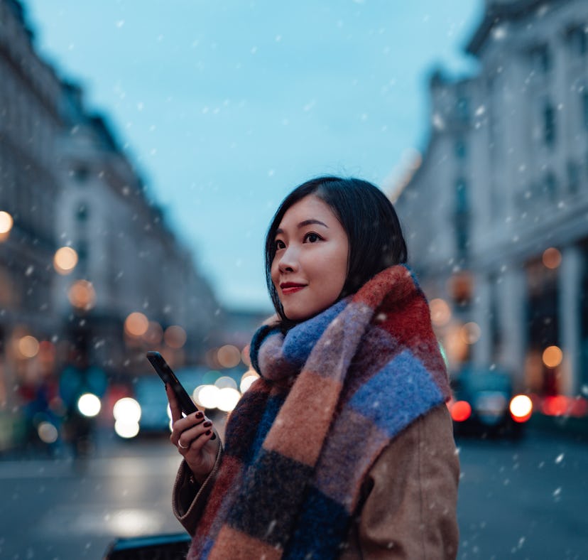 Young woman with scarf and winter coat, thinking about how her lucky zodiac sign will have the best ...