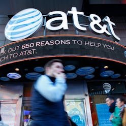 People walk past an AT&T store in New York on October 23, 2016. 
AT&T unveiled a mega-deal for Time ...