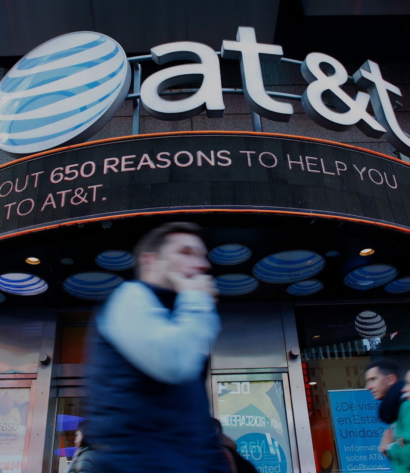 People walk past an AT&T store in New York on October 23, 2016. 
AT&T unveiled a mega-deal for Time ...