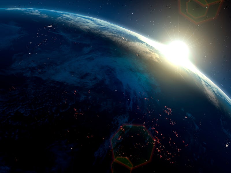 An impression of the Sun rising over the Earth, as seen from space. On the dark side of the Earth, c...