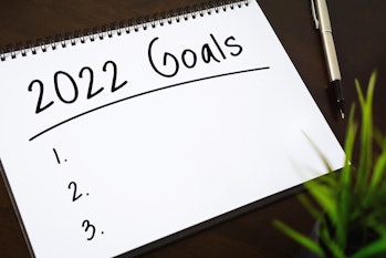 Photo of a white spiral notebook page that is blank except for the words "2022 Goals" and an empty l...