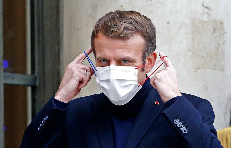 PARIS, FRANCE - DECEMBER 20: French President Emmanuel Macron takes off his protective face mask as ...
