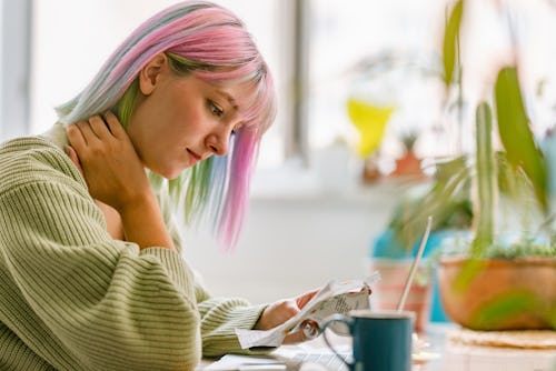 A woman looks over bills while drinking tea. Here's your daily horoscope for January 5 2022.