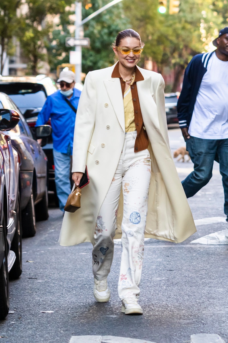 Gigi Hadid wearing a long white coat.