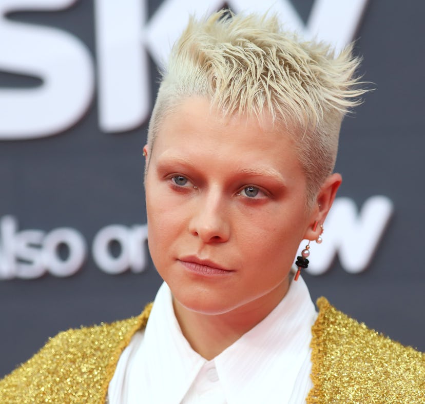 Emma D'Arcy from HBO's 'House of the Dragon' posing for a photo wearing a white shirt and gold vest....