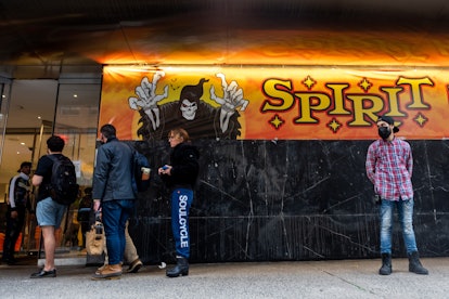 NEW YORK, NEW YORK - OCTOBER 26:  People wait in line outside a Spirit Halloween store in Chelsea on...