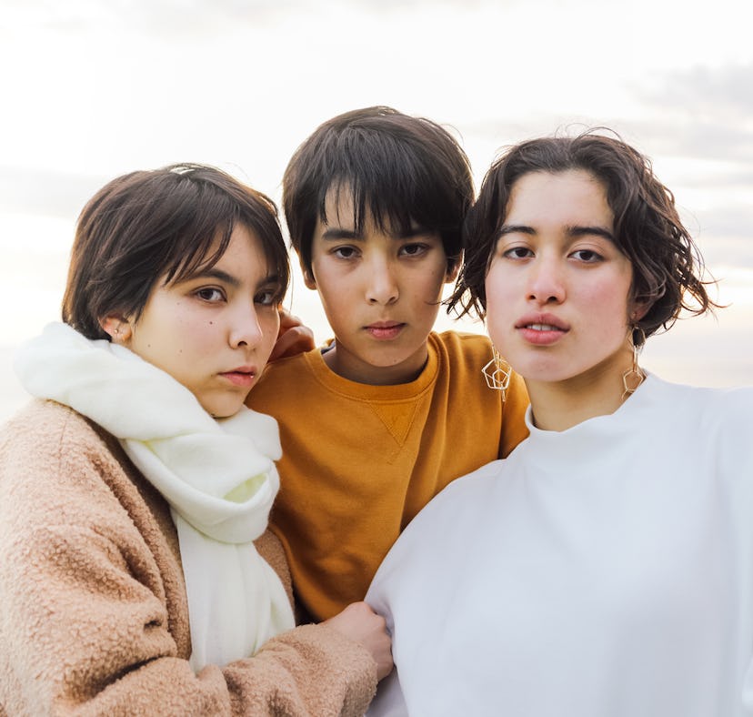 Three friends pose for a photo with serious expressions on their faces as they think about how the O...
