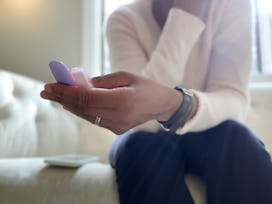 A hand holding two pregnancy tests in a story about how long does a miscarriage last.
