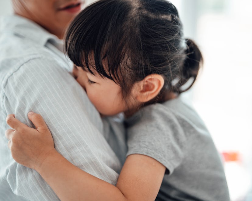 Little Asian girl feeling relax and comfortable in her dad’s arms. Loving father sharing parenting r...