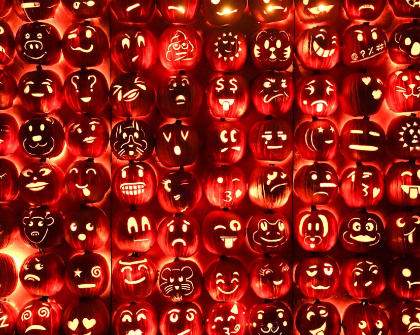 A wall of jack-o'-lanterns with various carvings, demonstrating some of the best jack-o'-lantern ide...
