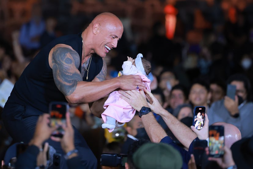 MEXICO CITY, MEXICO - OCTOBER 03: Dwayne Johnson holds a fan's baby during the black carpet for the ...