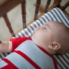 Baby sleeping in a crib on a breathable mattress.