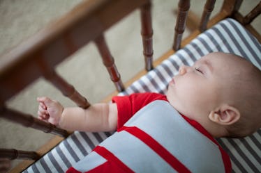 Baby sleeping in a crib on a breathable mattress.