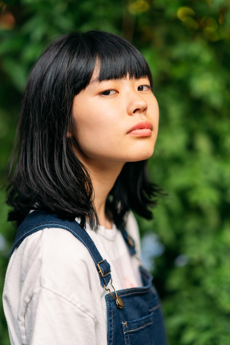 Young woman gazing into the camera, as she reflects on how the October 2022 new moon solar eclipse w...