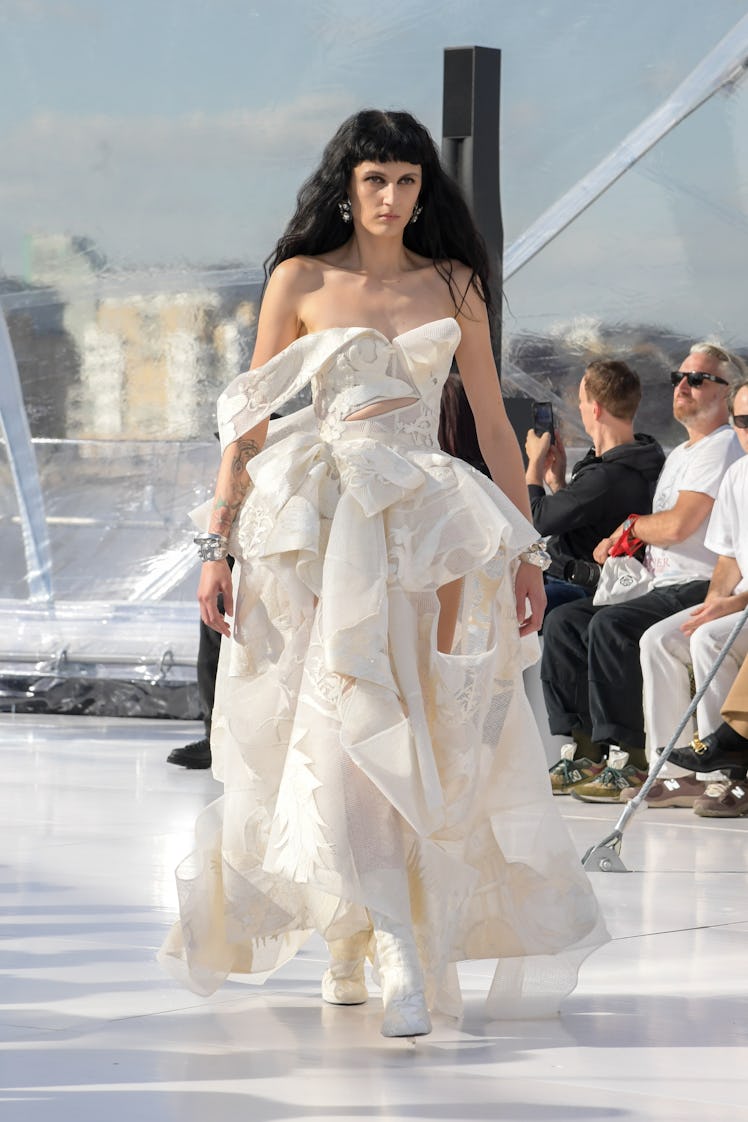 A model walking the runway in a white gown at the Alexander McQueen SS23 Womenswear show 