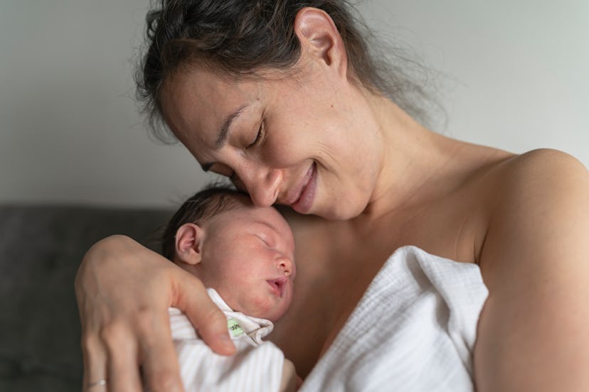 A woman of pacific island descent is snuggling her baby daughter after breastfeeding in an article a...