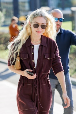 Gigi Hadid wearing a burgundy Guest In Residence jumpsuit.