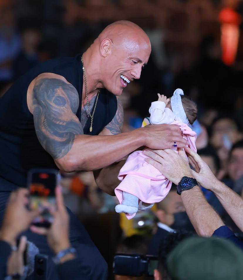 MEXICO CITY, MEXICO - OCTOBER 03: Dwayne Johnson holds a fan's baby during the black carpet for the ...