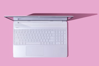 White laptop with hard shadow on pink background. Computer, Internet, PC, laptop and telecommuting c...