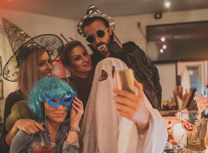 Group of costumed people at Halloween party use boo puns for instagram captions.