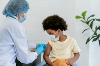 A little boy receives a vaccine from a healthcare worker. The variant booster for kids aged 5 and up...