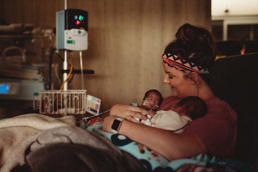 NICU premature twins are both held by mother on chest in NICU.