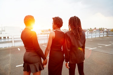 A couple holding hands with someone else who is part of an emotional cheating dynamic. 