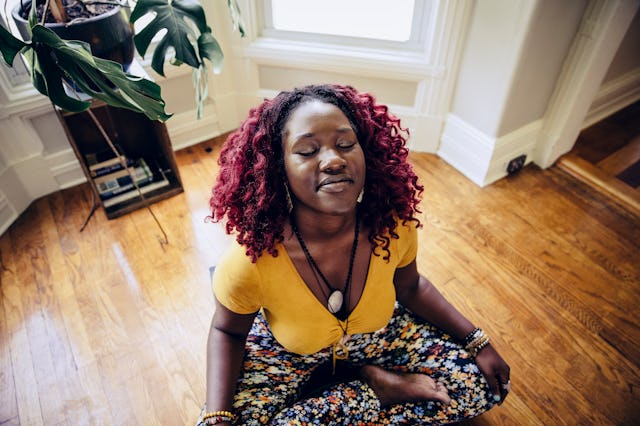 A young woman meditating, doing her self-care rituals