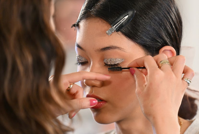 A model's makeup is done backstage for the Tory Burch Spring/Summer 2023 fashion show during New Yor...