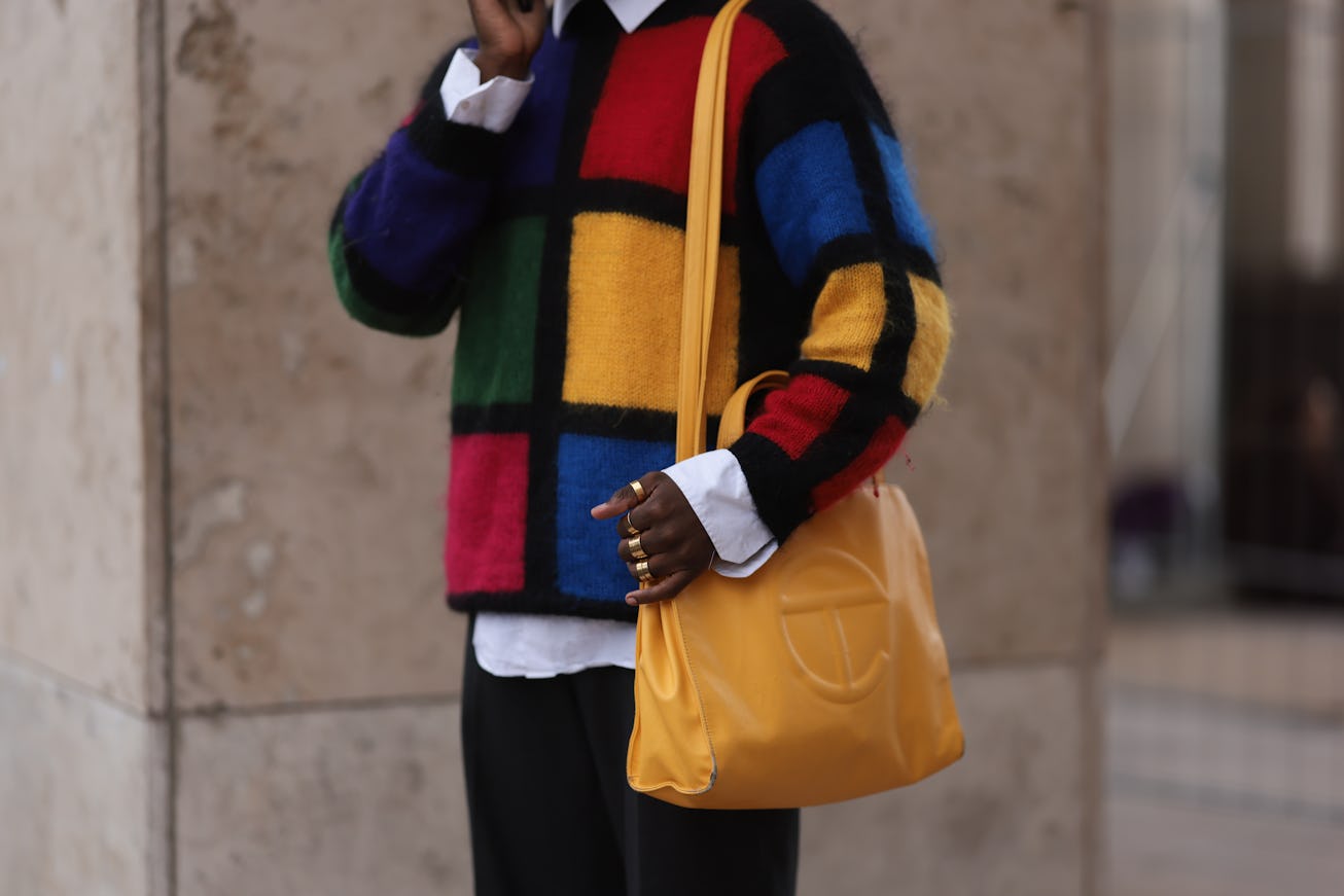 PARIS, FRANCE - SEPTEMBER 27: A fashion week guest seen wearing a yellow telfar bag with matching ye...